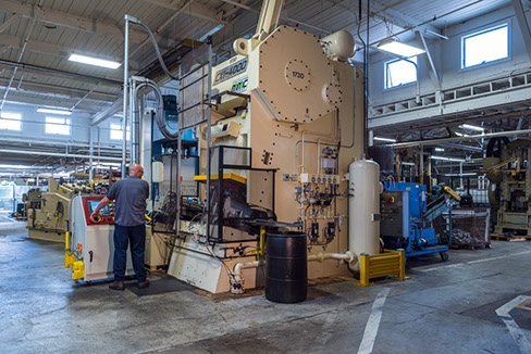 A Larson Tool & Stamping employee operating one of their cutting-edge metal stamping press.