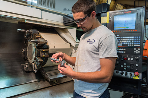 A Larson Tool & Stamping tool technician inspecting a machine.