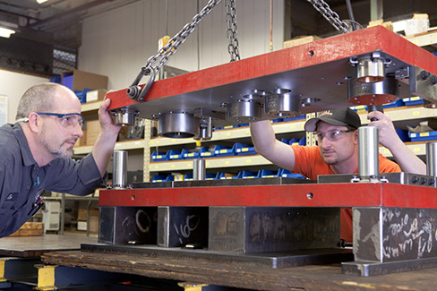 Two Larson Tool & Stamping toolmakers doing final inspection of a progressive die.